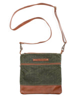 A green waxed canvas Ellis River crossbody bag with brown cowhide straps by Rogue Industries.