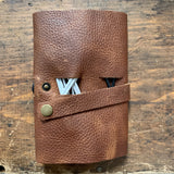 A brown Rogue Industries Leather Tech Organizer with cables attached to it.
