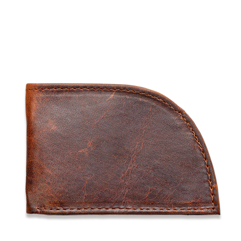 A weathered brown leather slim wallet, the Factory Second PREVIOUSLY EMBOSSED Made in Maine Front Pocket Wallet by Rogue Industries, features a curved bottom right corner and shows signs of wear and aging. The visible stitching around the edges adds to its rustic charm. This RFID-blocking wallet, crafted in Maine, is closed and appears empty.
