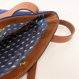 Uncovering the Sheepscot Felt Wool Tote Bag by Rogue Industries reveals a blue fabric interior adorned with a pattern of small white dogs, all wrapped in an exterior of felted wool and brown leather straps.